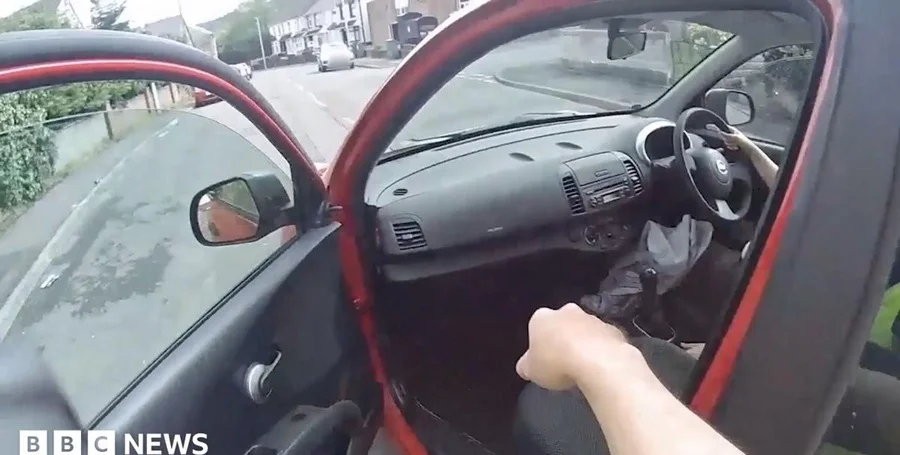 Woman driving red Nissan Micra